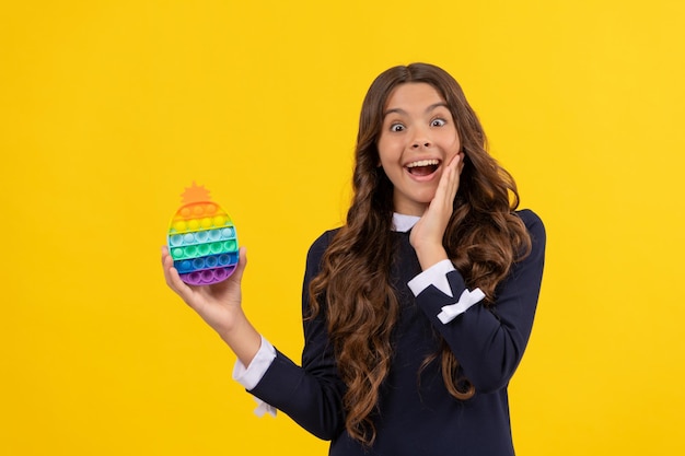 Menina adolescente espantada brinca com pop it silicone sensorial jogo de inquietação anti-stress