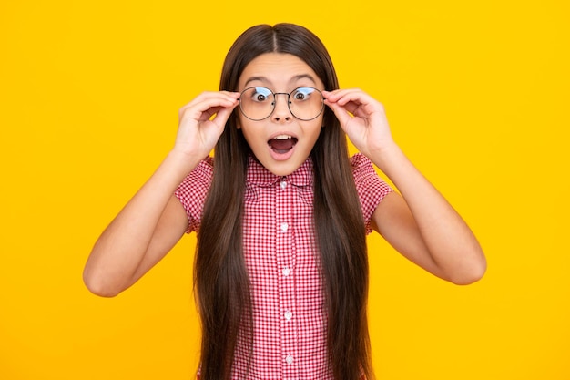 Menina adolescente espantada Expressão animada alegre e feliz Garota de tennager usa óculos olhando para a câmera com confiança sobre o espaço de cópia de fundo amarelo Garoto obtém visão