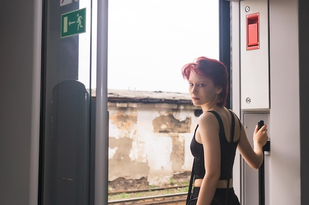 Menina adolescente está se preparando para sair em uma estação de um vagão de trem