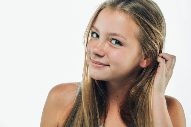 Menina adolescente está se tocando o cabelo. Retrato de mulher feminina com rosto de sardas. Tiro do estúdio.