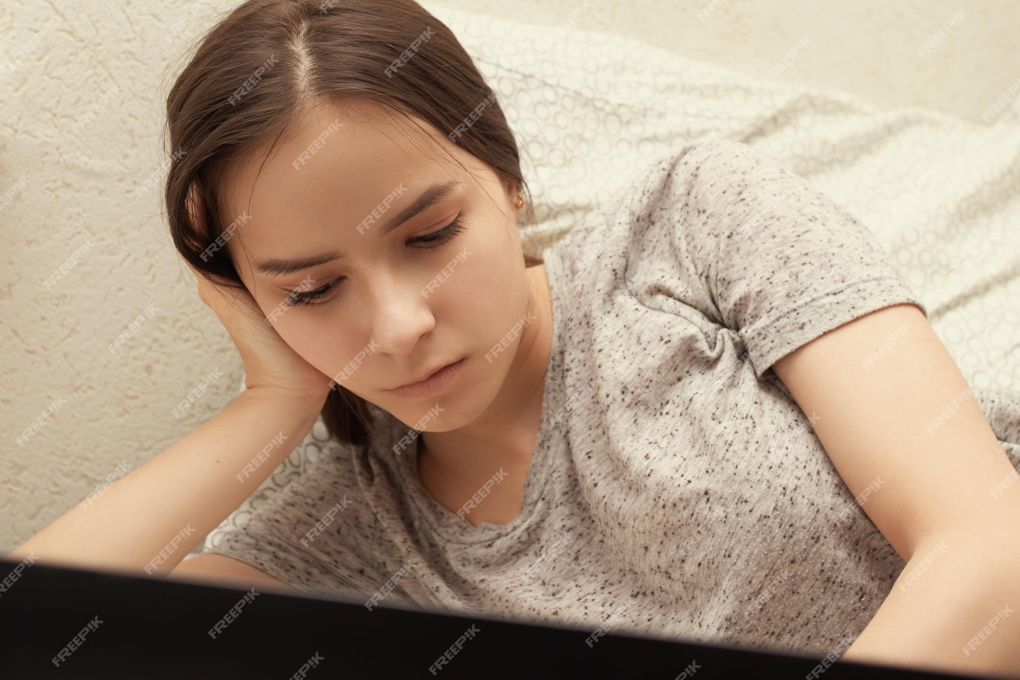 A menina encontra-se no sofá com o telefone. menina adolescente