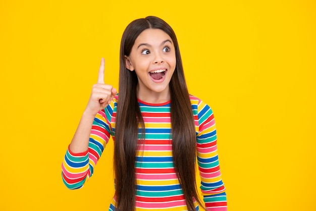 Menina adolescente excitada Criança adolescente confiante e bem-sucedida sobre fundo amarelo isolado