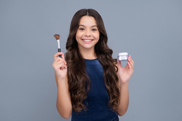 Menina adolescente fazendo maquiagem de beleza, segure pó e pincel Linda adolescente aplicando maquiagem com pó Garota feliz enfrenta emoções positivas e sorridentes