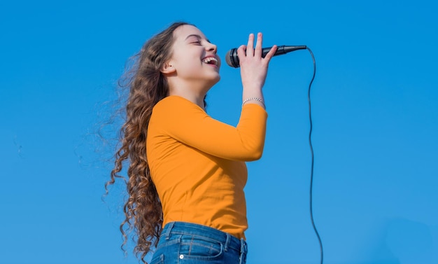 Foto menina adolescente feliz cantando karaokê no microfone