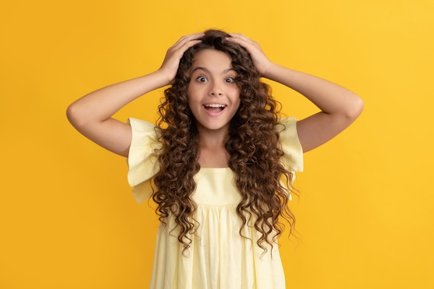 Menina adolescente feliz com cabelo longo encaracolado e pele perfeita expressa felicidade cabelo saudável