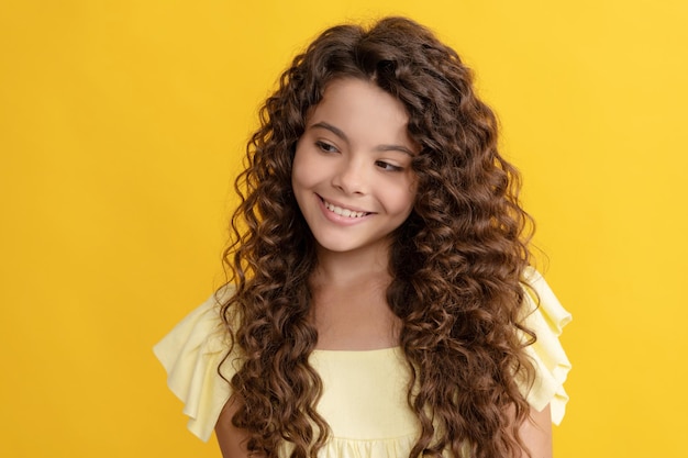 Menina adolescente feliz com longos cabelos cacheados e uma pele perfeita, cabelo