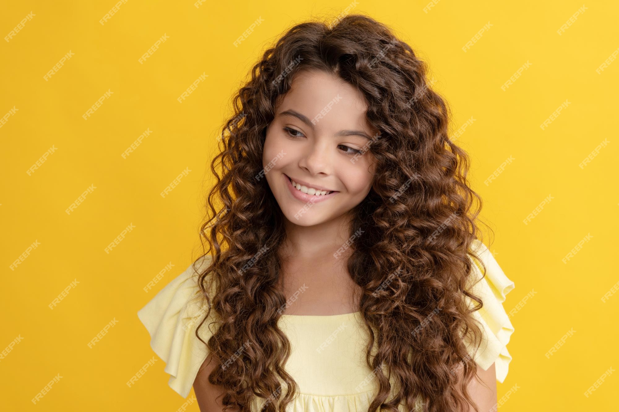 Menina adolescente feliz com longos cabelos cacheados e uma pele perfeita,  cabelo