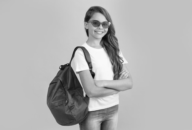 Menina adolescente feliz com mochila e notebook em óculos de sol prontos para estudar na educação escolar