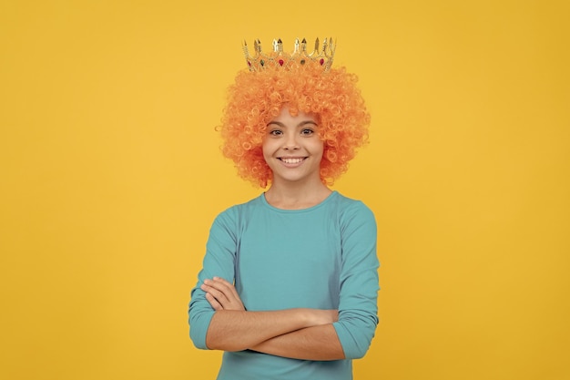 Menina adolescente feliz com peruca de palhaço chique usa coroa de rainha feminina