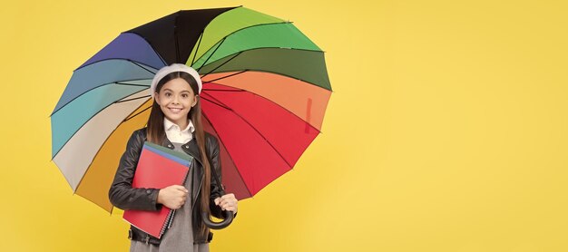 Menina adolescente feliz da escola de outono sob o guarda-chuva colorido para proteção contra chuva na temporada de outono, segure o caderno Retrato do cabeçalho do banner do estúdio do estudante da escola copyspace