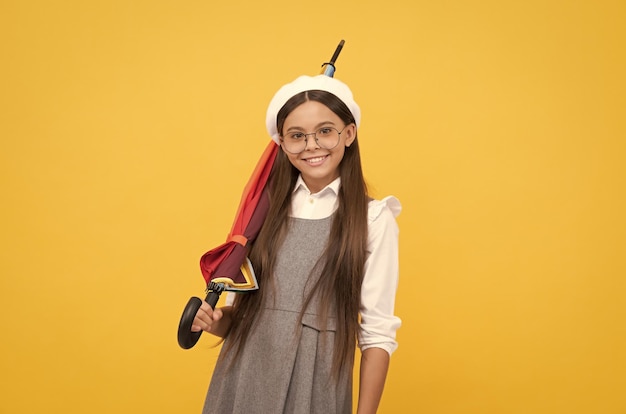 Menina adolescente feliz de óculos e boina segura guarda-chuva colorida para proteção contra chuva no outono outono