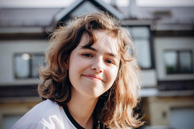 Menina adolescente feliz e sorridente com cabelo encaracolado ao ar livre