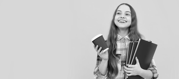 menina adolescente feliz em camisa quadriculada segurando xícara de café e caderno em fundo amarelo educação Banner de estudante criança escola retrato de aluno com espaço de cópia