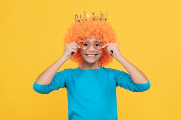 Menina adolescente feliz em peruca de palhaço chique usa coroa de rainha e óculos de festa engraçados felicidade