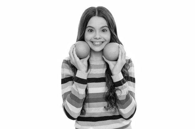 Menina adolescente feliz em suéter colorido com fruta laranja isolada na vida saudável branca