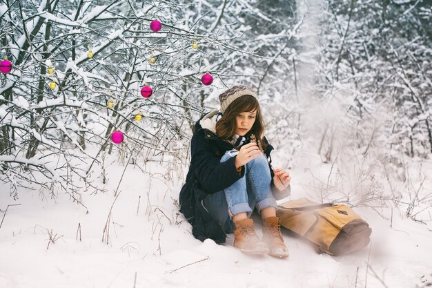 Menina adolescente feliz em uma caminhada de inverno em um dia de neve, Natal
