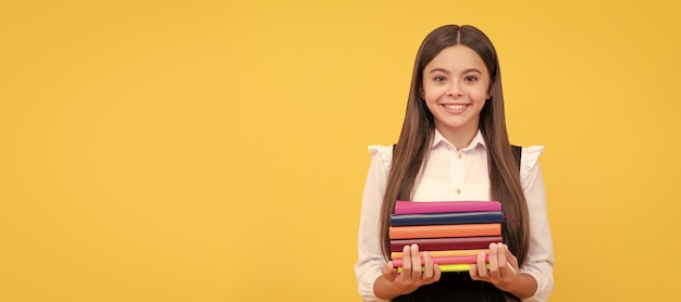 Menina adolescente feliz em uniforme escolar segurando pilha de livros lendo Banner de aluna da escola Retrato de aluna colegial com espaço de cópia