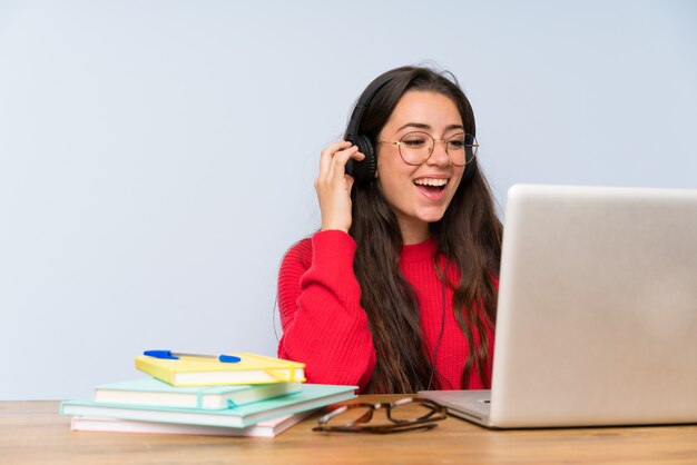 Menina adolescente feliz estudando em uma mesa