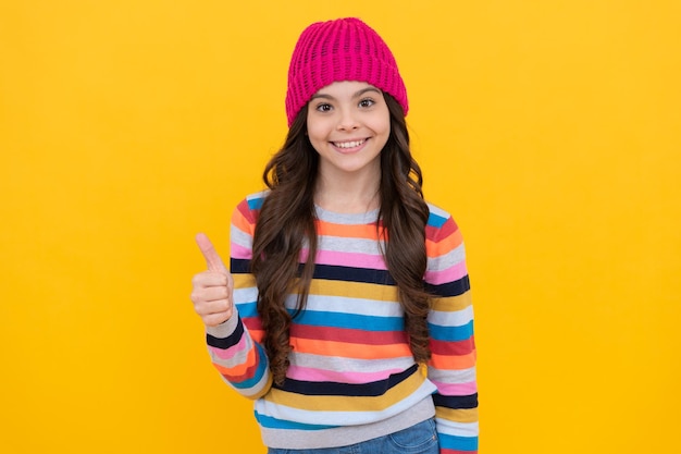 Menina adolescente feliz mostrando o polegar para cima a excelência do gesto