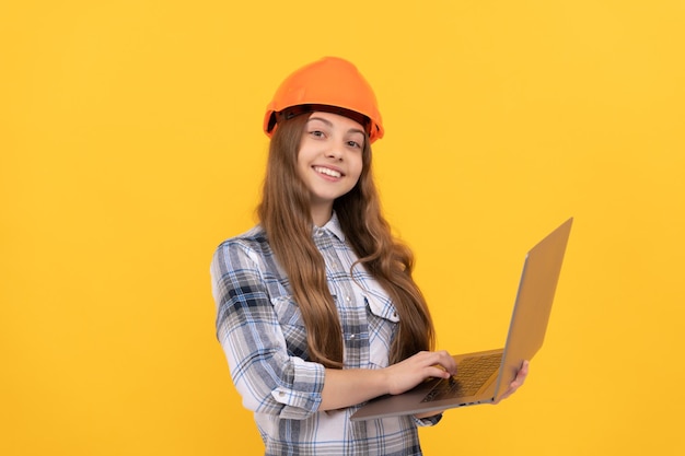 Menina adolescente feliz no capacete e camisa quadriculada usando educação portátil on-line