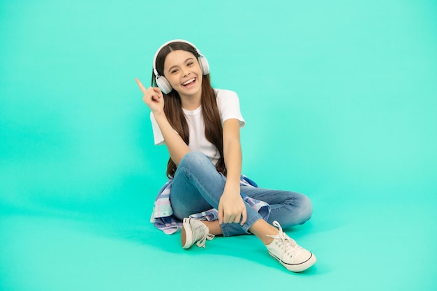 Menina adolescente feliz ouvir música em fones de ouvido sem fio, nova tecnologia.