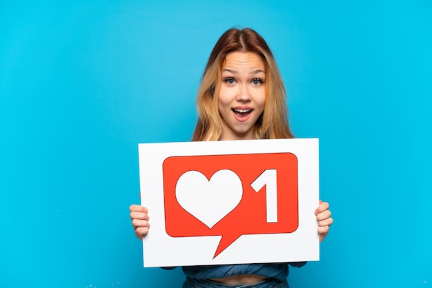 Menina adolescente isolada segurando um cartaz com o ícone "Like" com uma expressão feliz