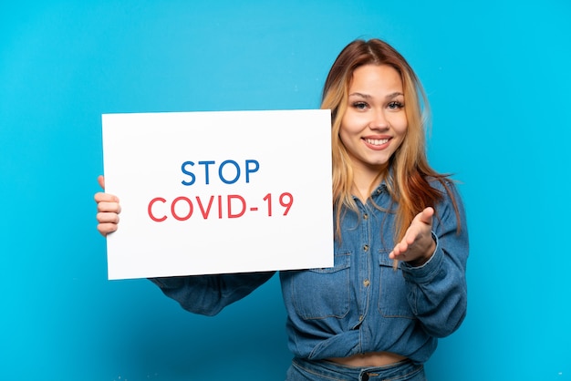 Menina adolescente isolada segurando um cartaz com o texto pare covid 19 fazendo um acordo