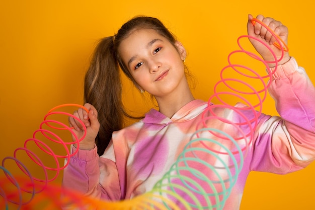 Foto menina adolescente joga brinquedo furtivo arco-íris na cor de fundo