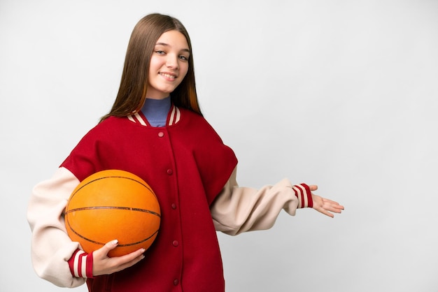 Menina adolescente jogando basquete sobre fundo branco isolado, estendendo as mãos para o lado para convidar para vir