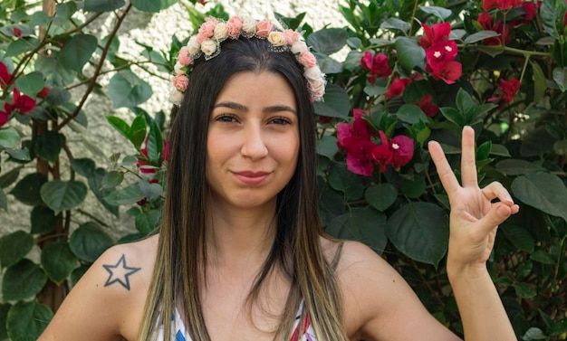 Foto menina adolescente morena bonita com tiara florida ou faixa de cabelo no jardim. conceito de fantasia de hippie.