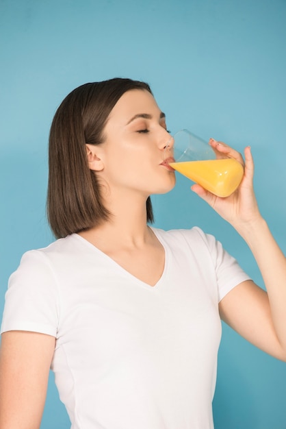 Menina adolescente morena com suco de laranja fresco