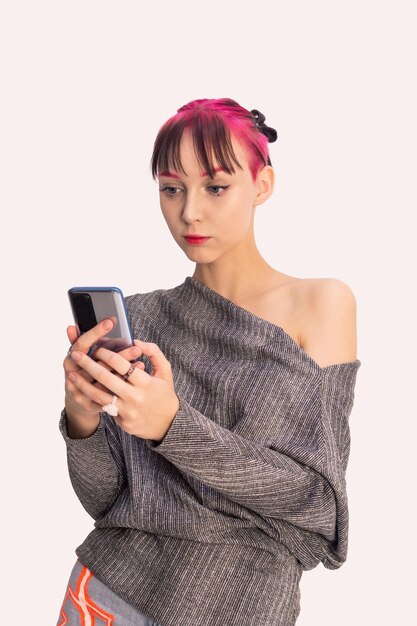 Menina adolescente olhando para um smartphone em um fundo claro