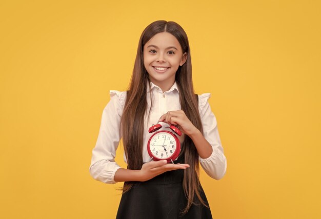 Menina adolescente pontual, verificando o tempo, criança feliz com despertador, garoto da escola de uniforme, mostrando o tempo