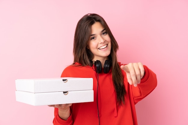 Menina adolescente segurando caixas de pizzas sobre parede isolada