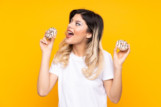 Menina adolescente segurando donuts