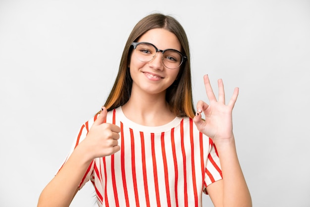 Foto menina adolescente sobre fundo branco isolado com óculos e fazendo sinal de ok