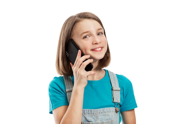 Menina adolescente sorridente, falando em um smartphone. Comunicação e tecnologia. .