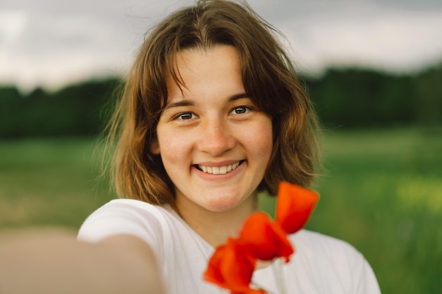 Menina adolescente sorrindo e olhando para a câmera e tira uma selfie conceito de estilo de vida retrato de menina adolescente