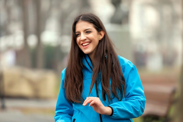 Menina adolescente sorrindo no parque verde na tarde ensolarada de verão