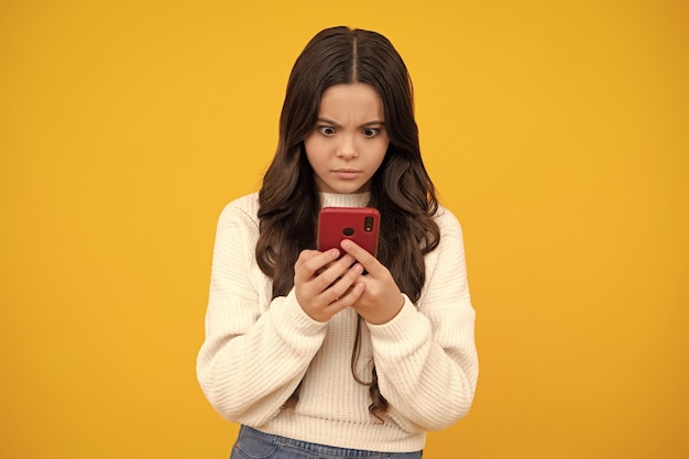 Menina adolescente surpresa Criança adolescente usando telefone celular conversando na web Aplicativo móvel para smartphone Conceito de estilo de vida infantil