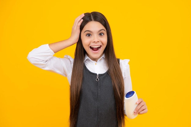 Menina adolescente surpresa Menina adolescente mostrando condicionadores de xampu ou gel de banho Cosmético para o cabelo