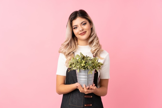 Menina adolescente tomando um vaso de flores