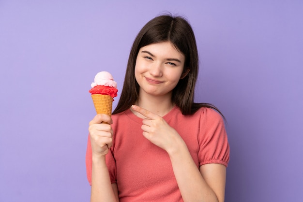 Menina adolescente ucraniana jovem segurando um sorvete de corneta sobre parede roxa