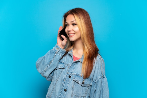 Menina adolescente usando telefone celular em um fundo isolado, olhando de lado