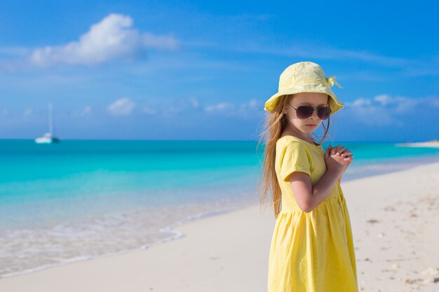 Menina adorável na praia branca durante as férias de verão