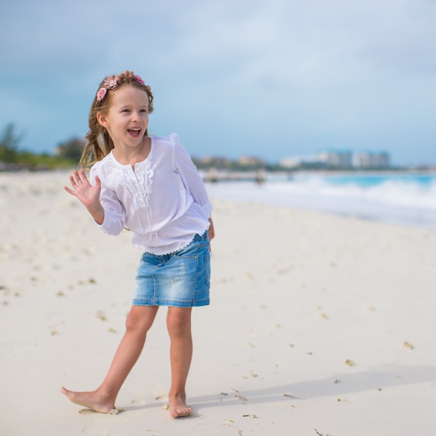 Menina adorável na praia branca durante as férias de verão