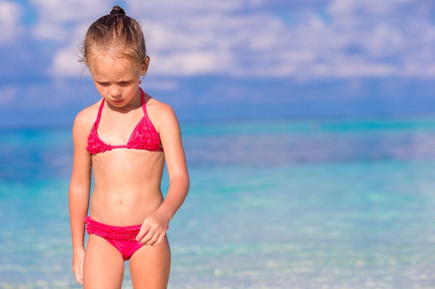 Menina adorável na praia durante as férias de verão