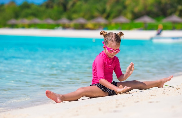 Menina adorável na praia durante as férias de verão