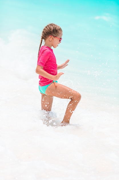 Menina adorável na praia nas férias de verão