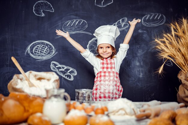 Menina adorável no chapéu de chef